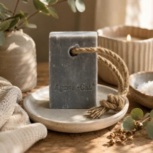 Agnes + Cat Soap on a Rope β Windermere displayed on a ceramic soap dish with eucalyptus, soft linen and natural botanicals, creating a calm spa-inspired bathroom scene with warm natural light and a slow living atmosphere.