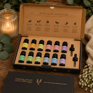 Starter Pack Essential Oil Gift Set displayed in an open premium gift box on a rustic wooden table with twelve essential oils, glass droppers, eucalyptus leaves, soft linen and a glowing candle in a calming spa-inspired slow living setting.