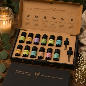 Summer Essential Oil Gift Set displayed in an open premium gift box on a rustic wooden table with twelve essential oils, glass droppers, eucalyptus leaves, soft linen and a glowing candle in a calming spa-inspired slow living setting.