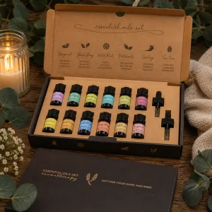 Top 12 Essential Oil Gift Set displayed in an open premium gift box on a rustic wooden table with twelve essential oils, glass droppers, eucalyptus leaves, soft linen and a glowing candle in a calming spa-inspired slow living setting.