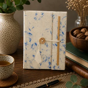 Handmade medium Lokta paper notebook with natural cream paper and delicate blue cotton fibres, wooden button closure and bamboo detail