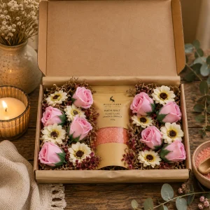 Salt Soak Set – Passion displayed in an open kraft gift box with 350g Ylang Ylang, Lemon & Orange bath salts surrounded by pink soap roses and soap sunflowers.